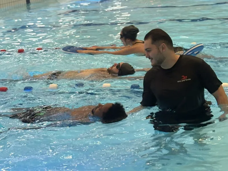 Antrenor Win and Swim asistând un cursant la plutirea pe spate